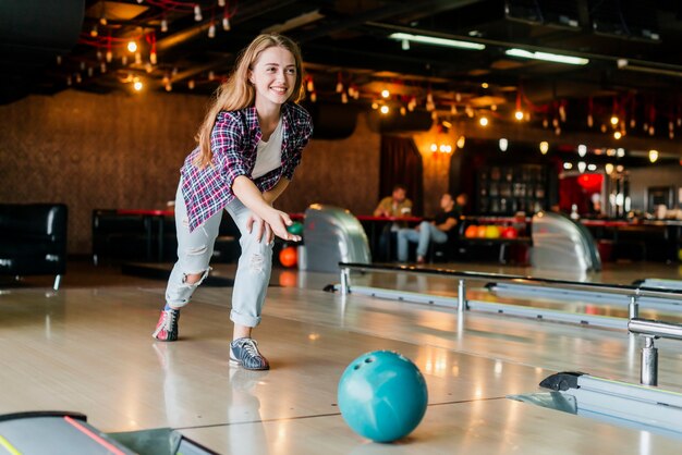 Jovem mulher brincando com uma bola de boliche