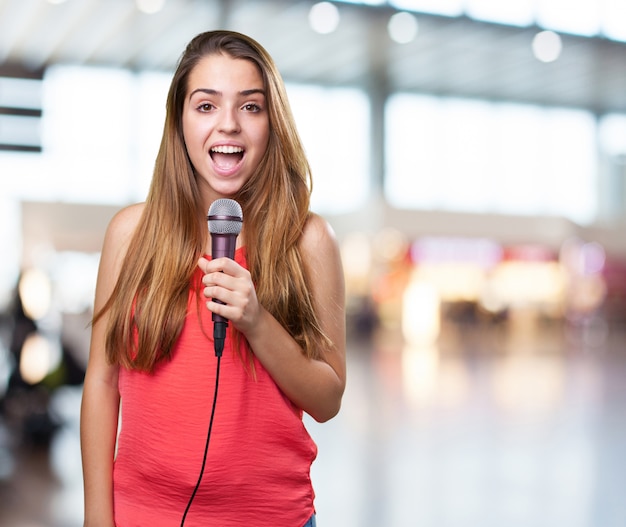 jovem mulher cantando com um microfone no fundo branco