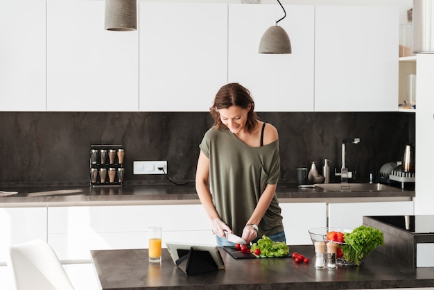 Jovem mulher casual, cozinhar salada fresca