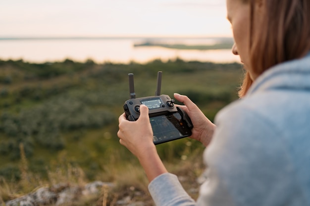 Jovem mulher caucasiana navegando um avião voando com controle remoto