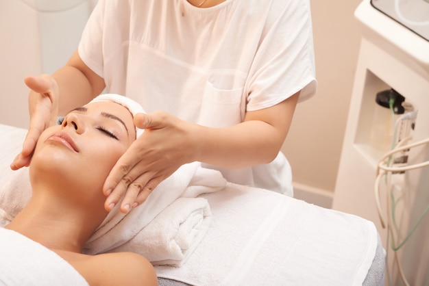Jovem mulher caucasiana, recebendo massagem anti-idade