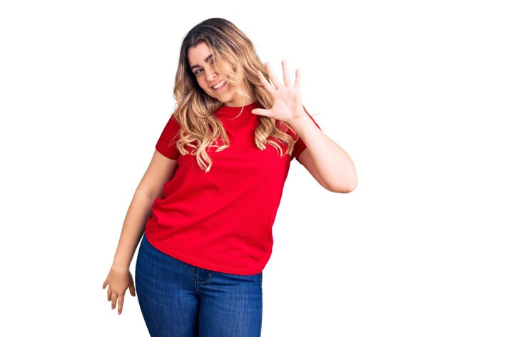 Foto grátis jovem mulher caucasiana vestindo roupas casuais mostrando e apontando para cima com os dedos número cinco enquanto sorria confiante e feliz.