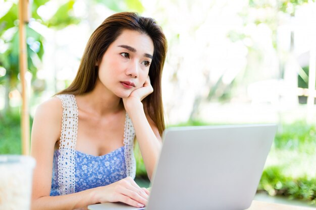 Jovem mulher chata enquanto usar laptop