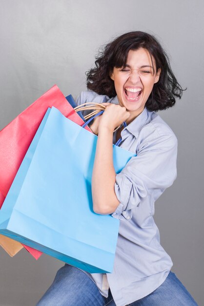 Jovem mulher chorando com sacos de compras