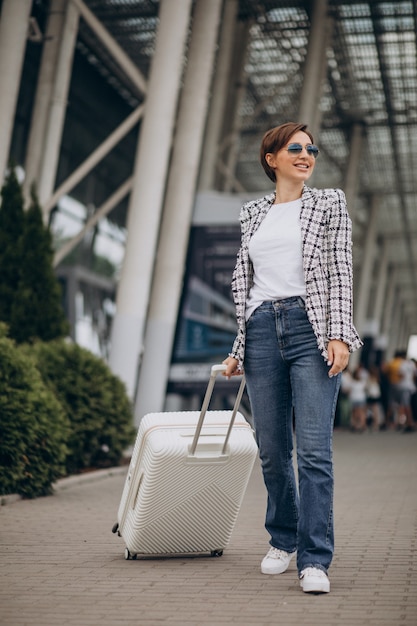 Foto grátis jovem mulher com bagagem no aeroporto viajando