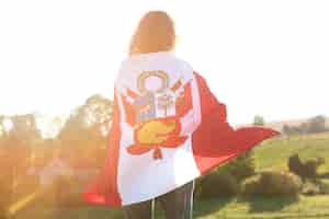 Foto grátis jovem mulher com bandeira do peru ao ar livre