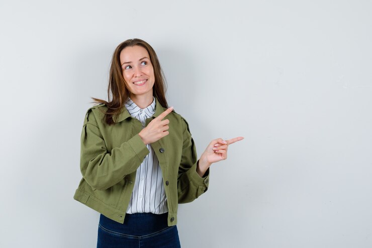 Foto grátis jovem mulher com camisa, jaqueta apontando para o lado direito e parecendo um sonho, vista frontal.