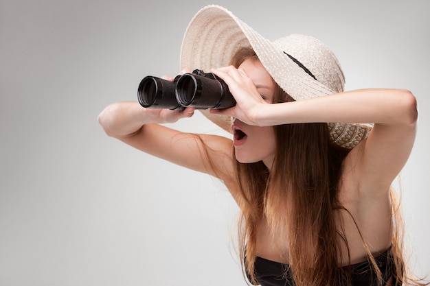 Foto grátis jovem mulher com chapéu com binóculos