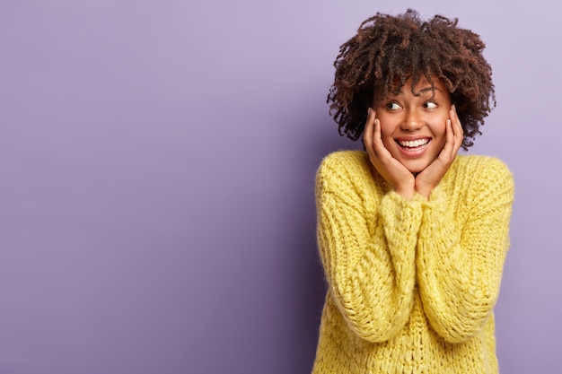 Foto grátis jovem mulher com corte de cabelo afro e suéter amarelo