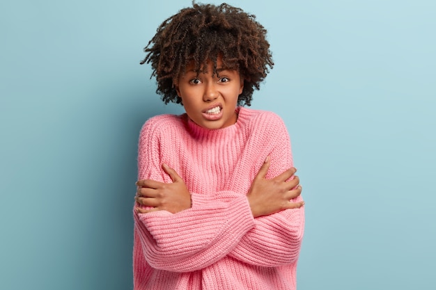 Foto grátis jovem mulher com corte de cabelo afro e suéter rosa