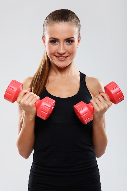 Jovem mulher com dumbells