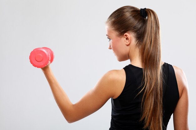 Jovem mulher com dumbells