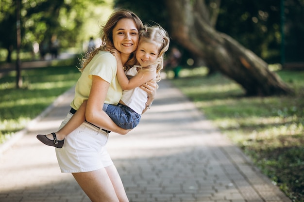 Jovem mulher com filha caminhando no parque