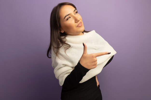 Jovem mulher com lenço branco olhando para o lado sorrindo e apontando com o dedo para o lado