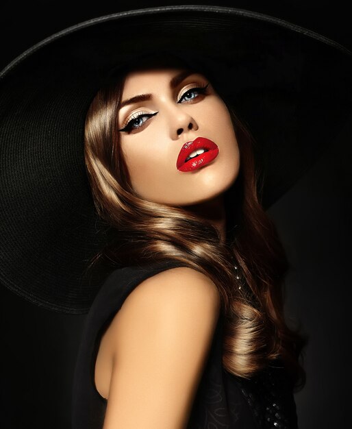 Jovem mulher com maquiagem brilhante e chapéu preto