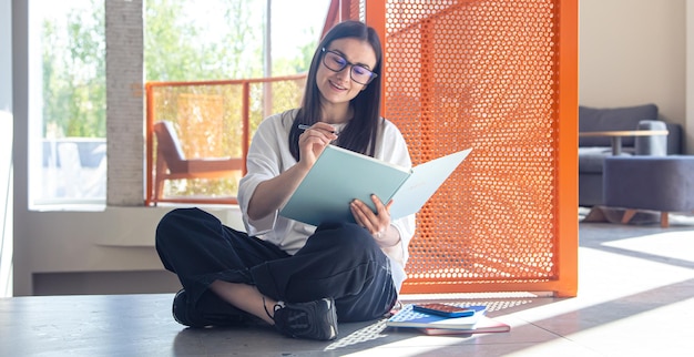 Foto grátis jovem mulher com óculos e notebook no conceito moderno de estudo de interiores