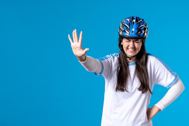 Foto grátis jovem mulher com roupas esportivas e capacete na parede azul de frente