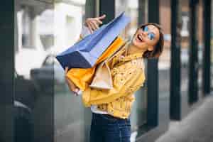 Foto grátis jovem mulher com sacolas de compras na cidade