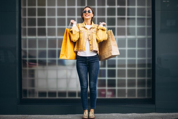 Jovem mulher com sacolas de compras na cidade