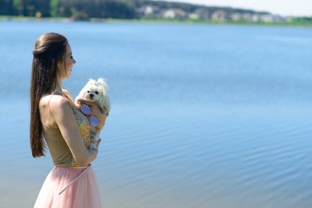 Jovem mulher com seu cachorro. cachorro branco está correndo com seu dono. conceito sobre amizade e animais.