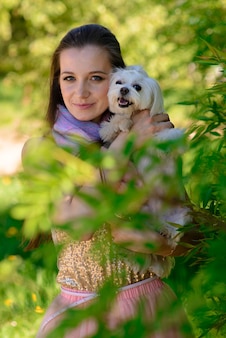 Jovem mulher com seu cachorro. cachorro branco está correndo com seu dono. conceito sobre amizade e animais.