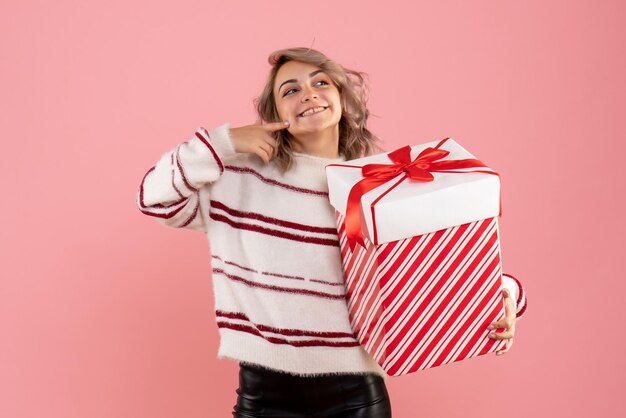 Jovem mulher com um presente de natal de frente