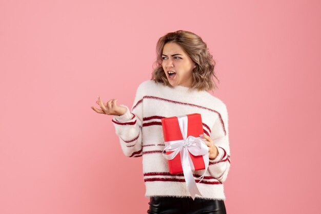 Jovem mulher com um presente de natal de frente