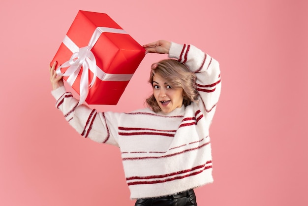 Jovem mulher com um presente de natal de frente