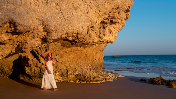 Foto grátis jovem mulher com um vestido branco junto ao mar