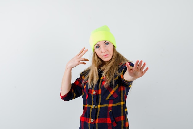 Foto grátis jovem mulher com uma camisa xadrez e um chapéu