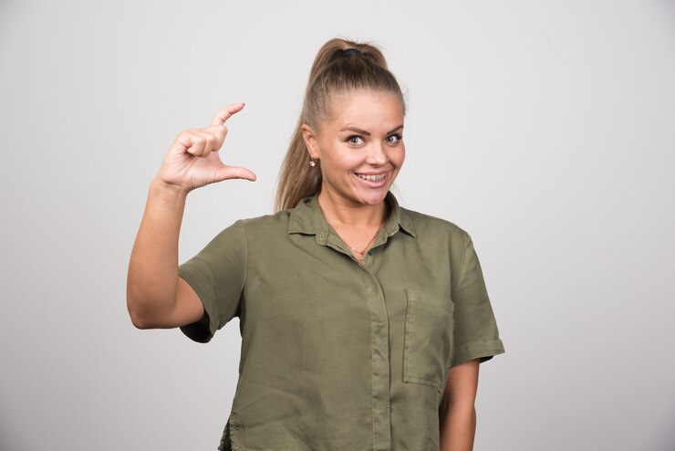 Foto grátis jovem mulher com uma jaqueta verde, oferecendo a mão para apertar.
