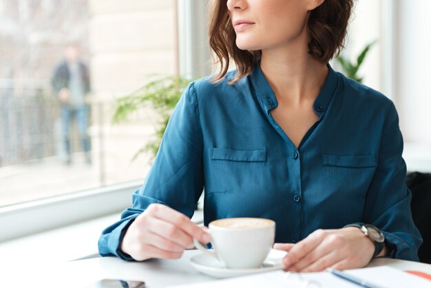 Jovem mulher com uma xícara de café em um café