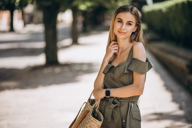 Jovem mulher com vestido verde fora no parque