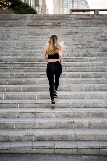 Jovem mulher correndo ao ar livre com sportswear