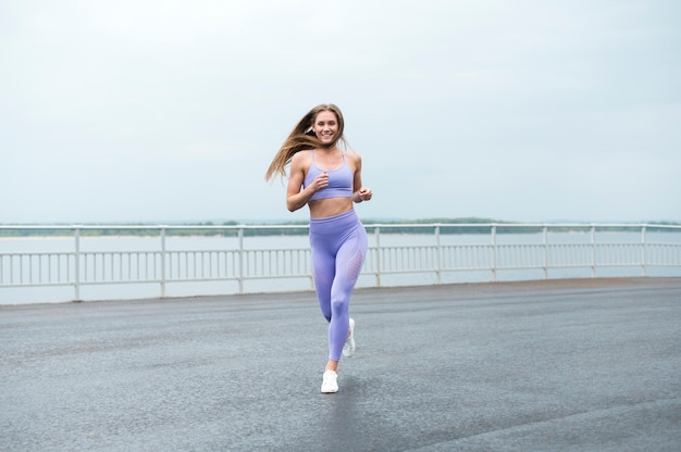 Jovem mulher correndo ao longo do lago