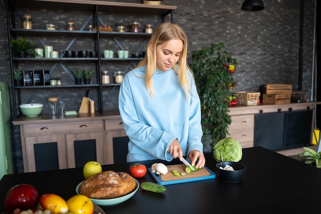 Jovem mulher cozinhando na cozinha