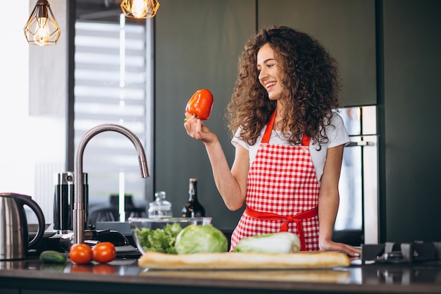 Jovem mulher cozinhando na cozinha