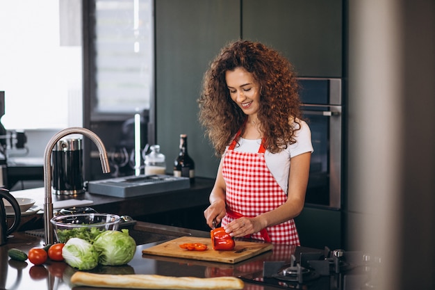 Jovem mulher cozinhando na cozinha