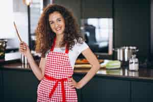 Foto grátis jovem mulher cozinhando na cozinha