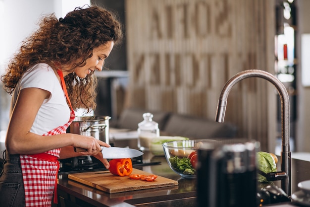 Jovem mulher cozinhando na cozinha