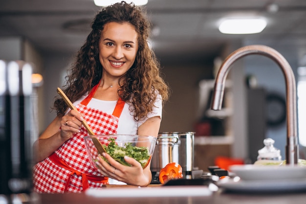 Jovem mulher cozinhando na cozinha