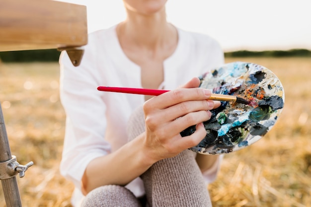 Jovem mulher criativa segurando a paleta de pintura