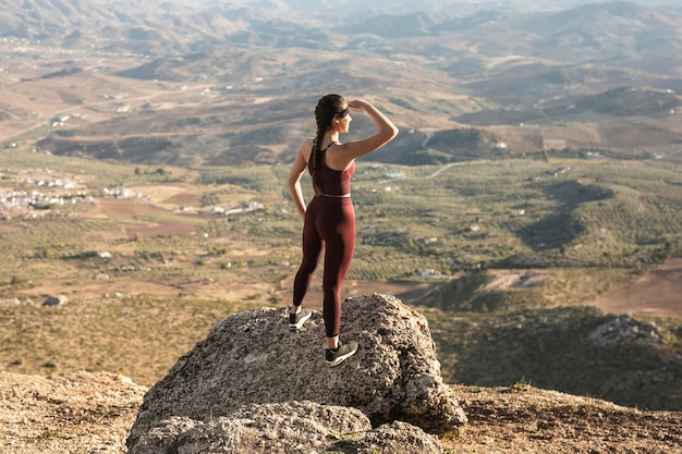 Jovem mulher de alto ângulo na montanha, olhando para longe