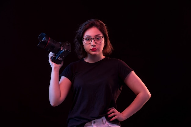 Jovem mulher de camiseta preta com câmera