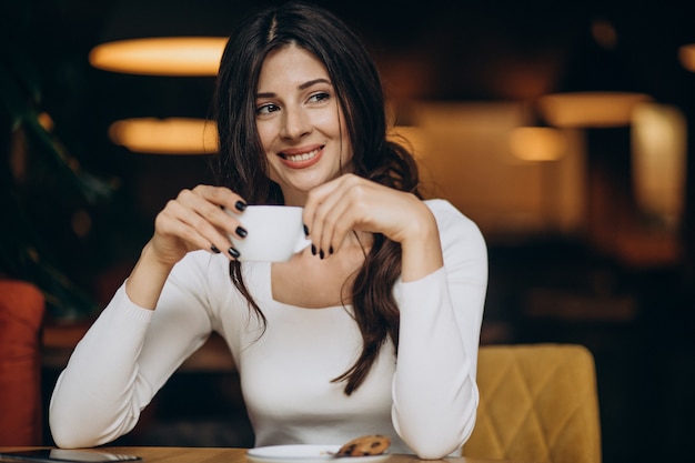 Jovem mulher de negócios tomando café em um café