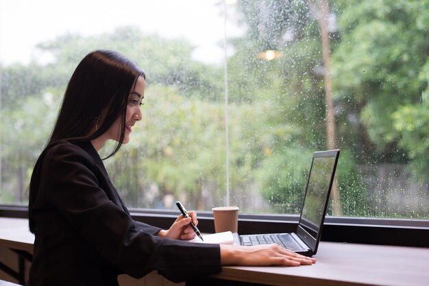 Jovem mulher de negócios trabalha no laptop no escritório