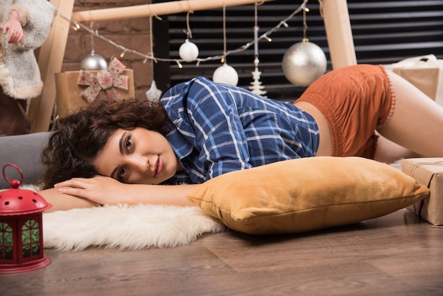 Foto grátis jovem mulher deitada e posando com um travesseiro