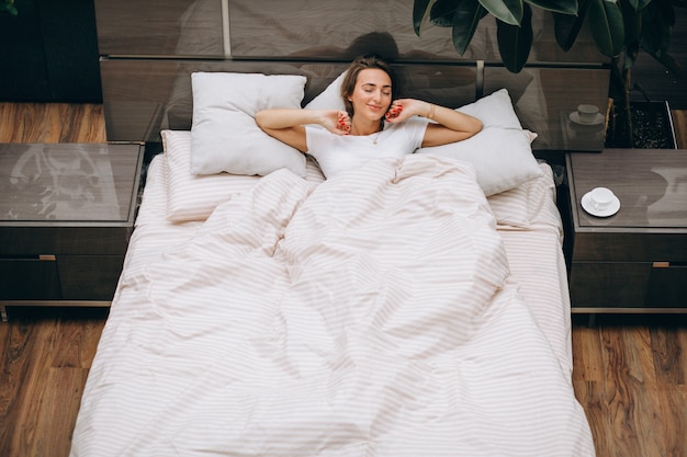 Jovem mulher descansando na cama de manhã