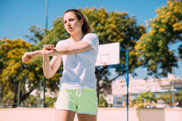 Jovem mulher determinada que aquece os braços