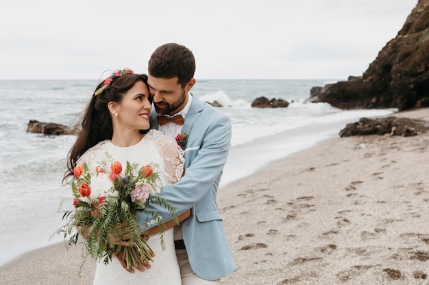 Jovem mulher e homem se casando na praia